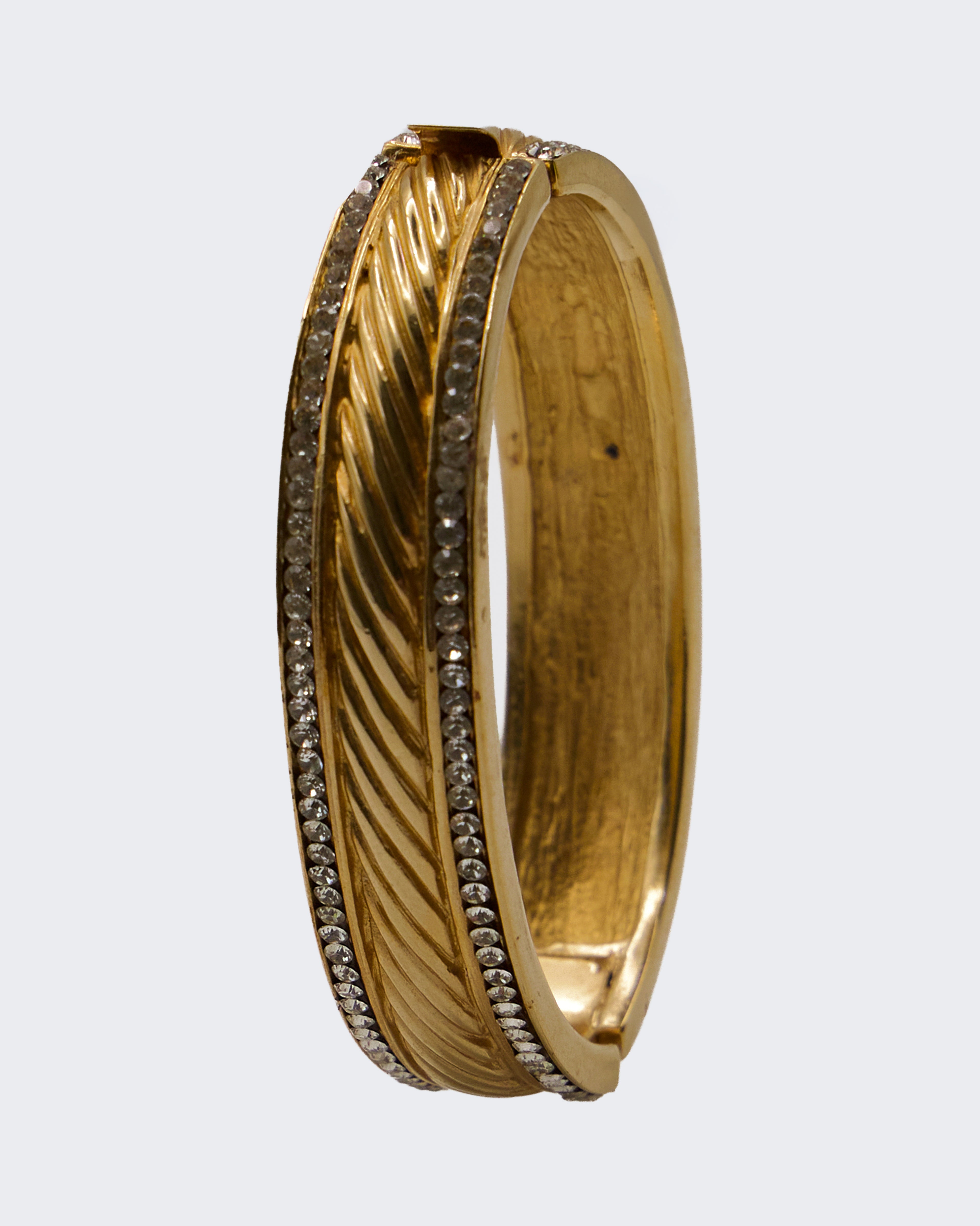 Bracciale Rigido Dorato con Cerniera e Cristalli – Motivo Piuma Intrecciata