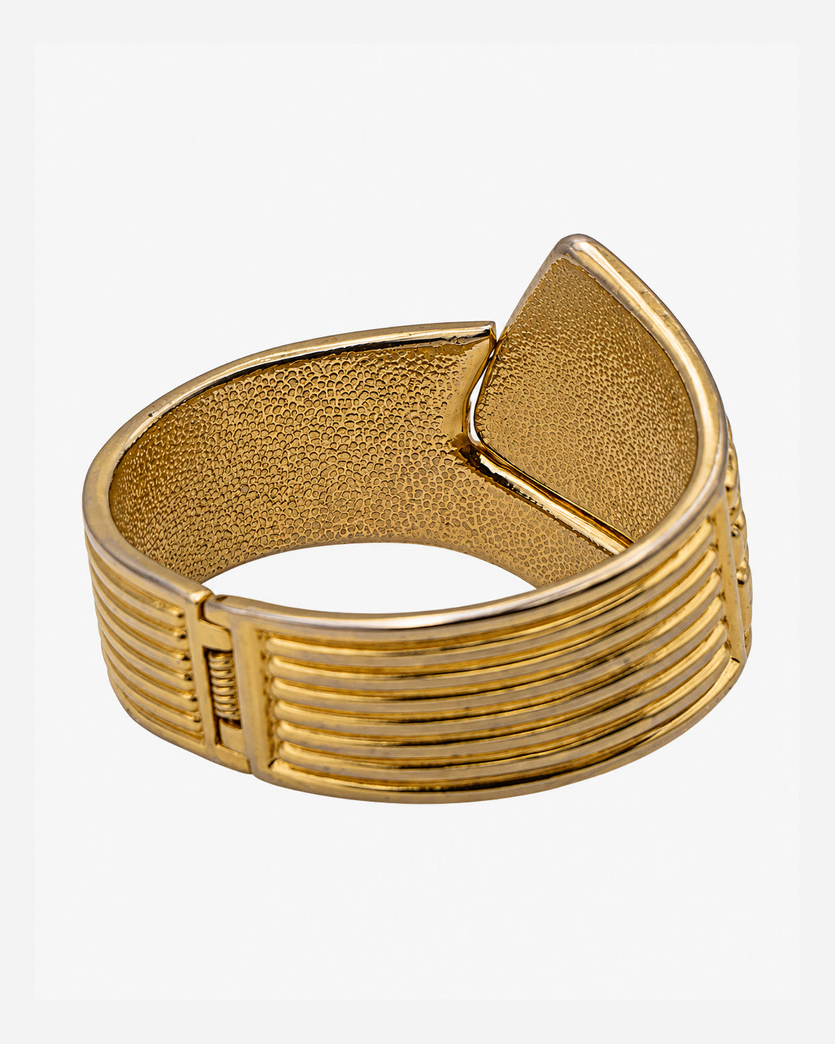 Retro del bracciale vintage dorato con fascia scanalata, cerniera a molla e superficie interna lavorata.