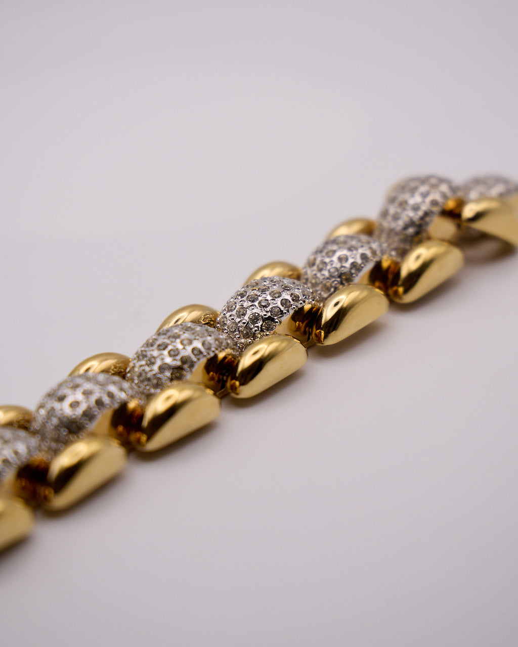 Dettaglio delle maglie bombate con pavé e degli elementi laterali dorati del bracciale