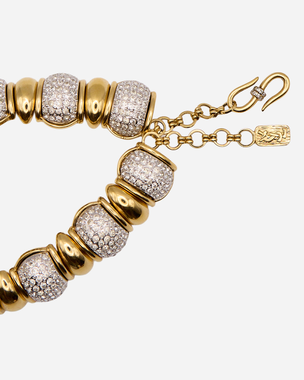Dettaglio degli elementi a pavé della collana YSL, della catena ad anelli e della chiusura a S.