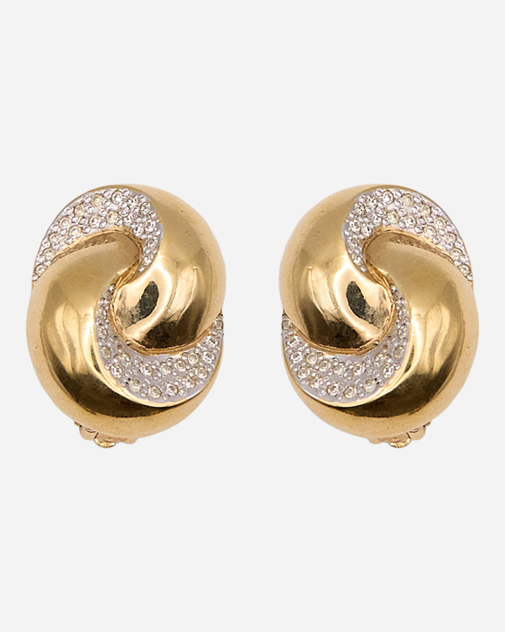 Orecchini vintage ovali con motivo a nodo dorato e fasce curve di cristalli a pavé su fondo argentato.